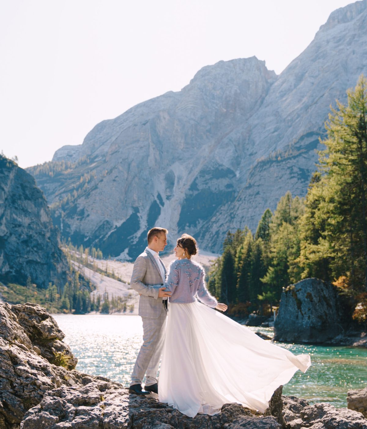 The,Bride,And,Groom,Are,Standing,On,Stones,Overlooking,The